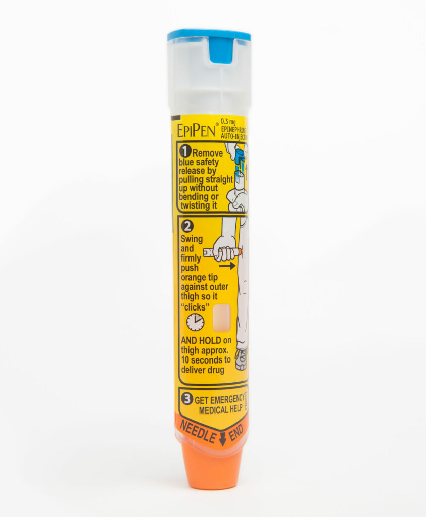An EpiPen standing an a white background